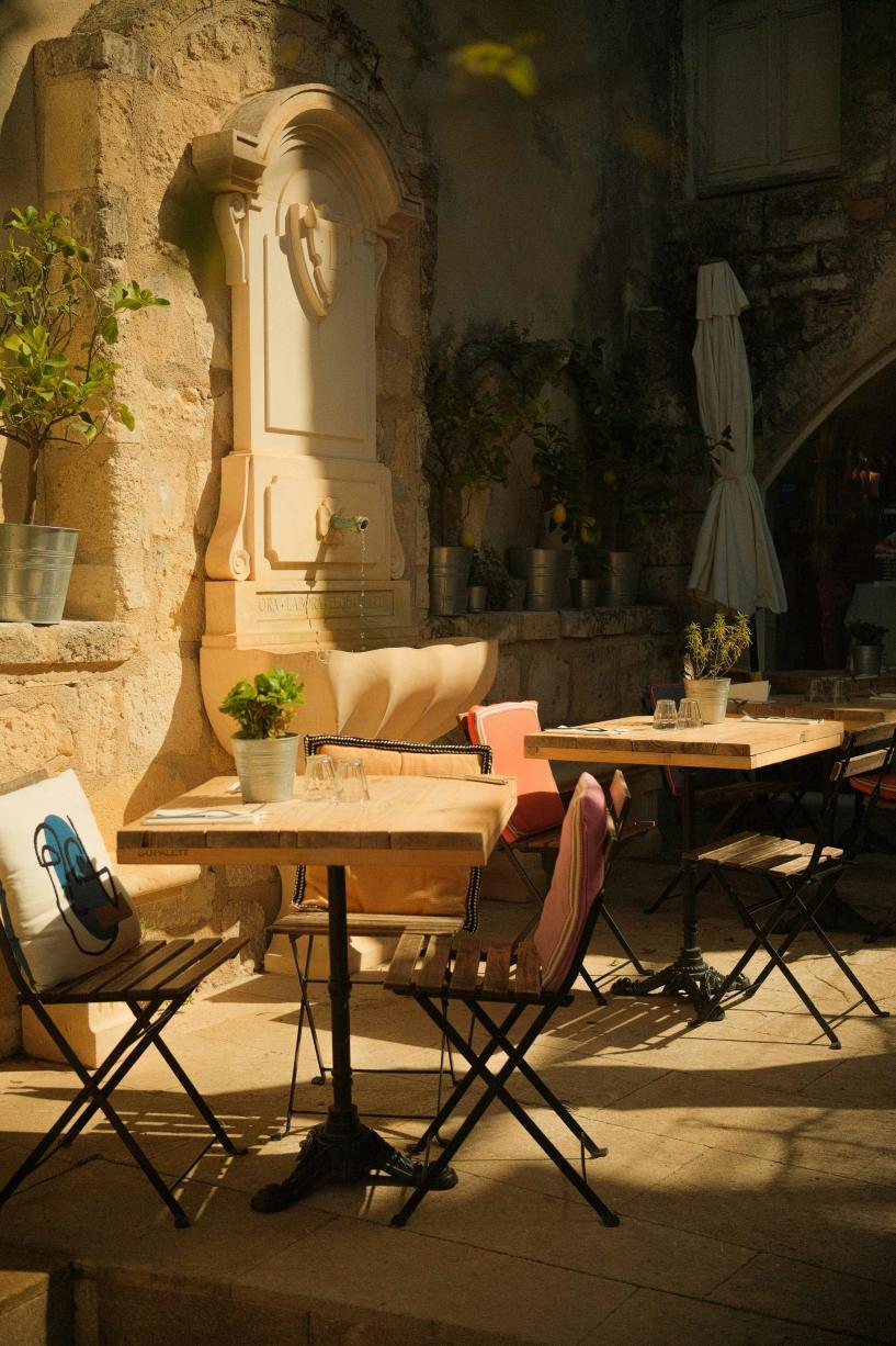 Une terrasse au soleil, près d'une fontaine 